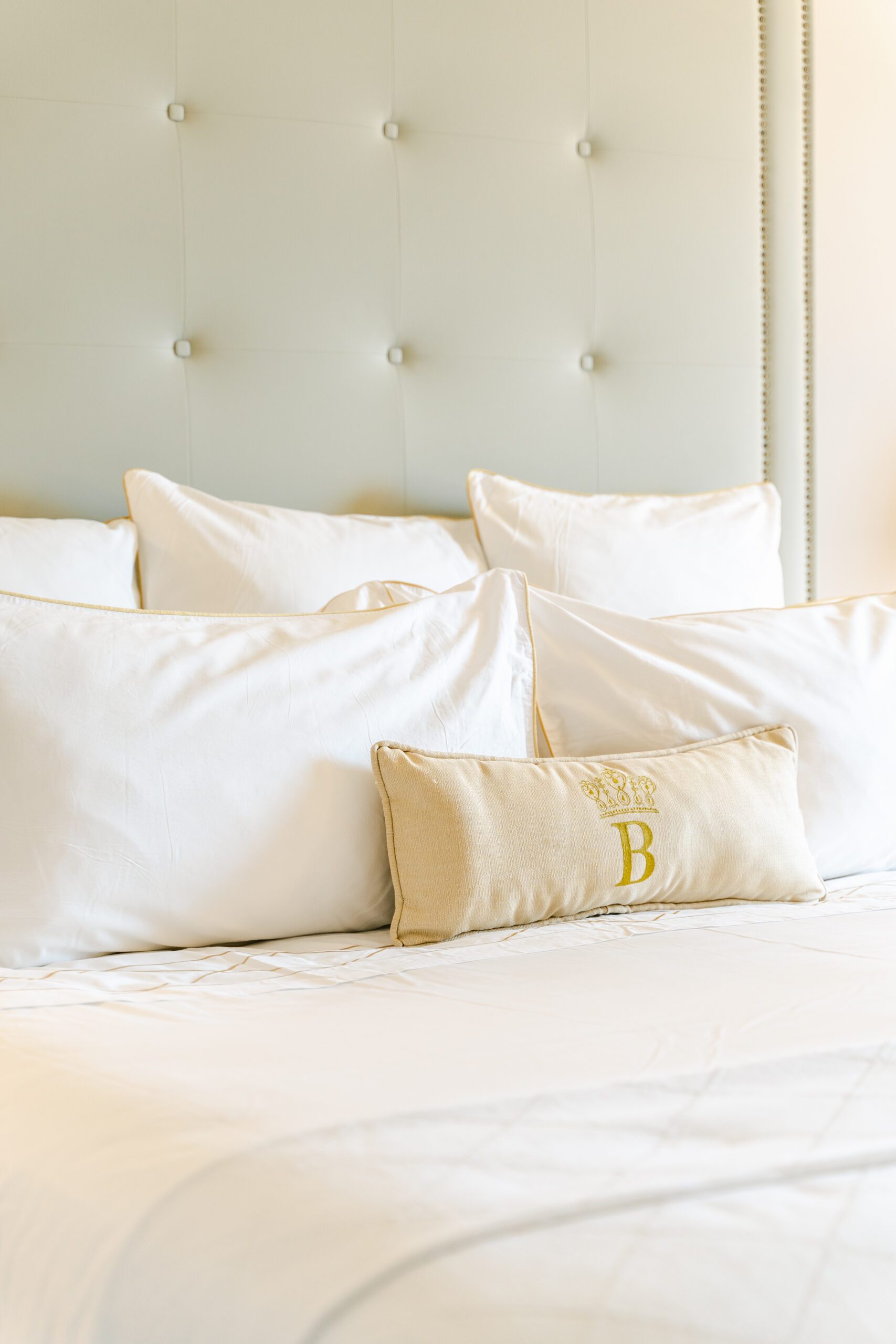 luxury hotel bed with monogrammed pillows