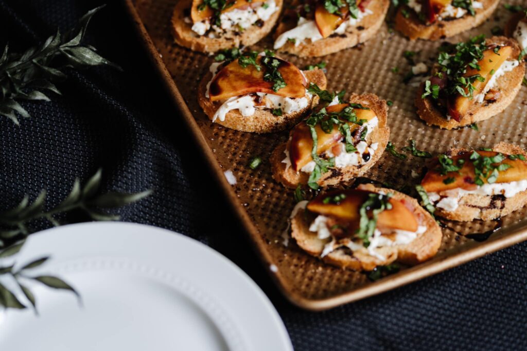 peach and burrata crostinis on baking sheet